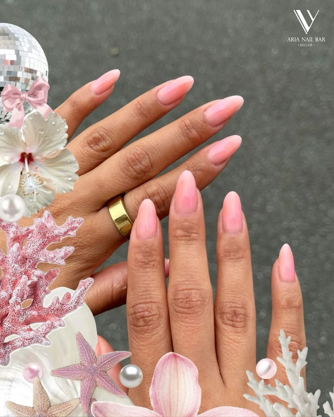 Sheer pink ombre almond nails photographed among pink coral, pearls and seashells.