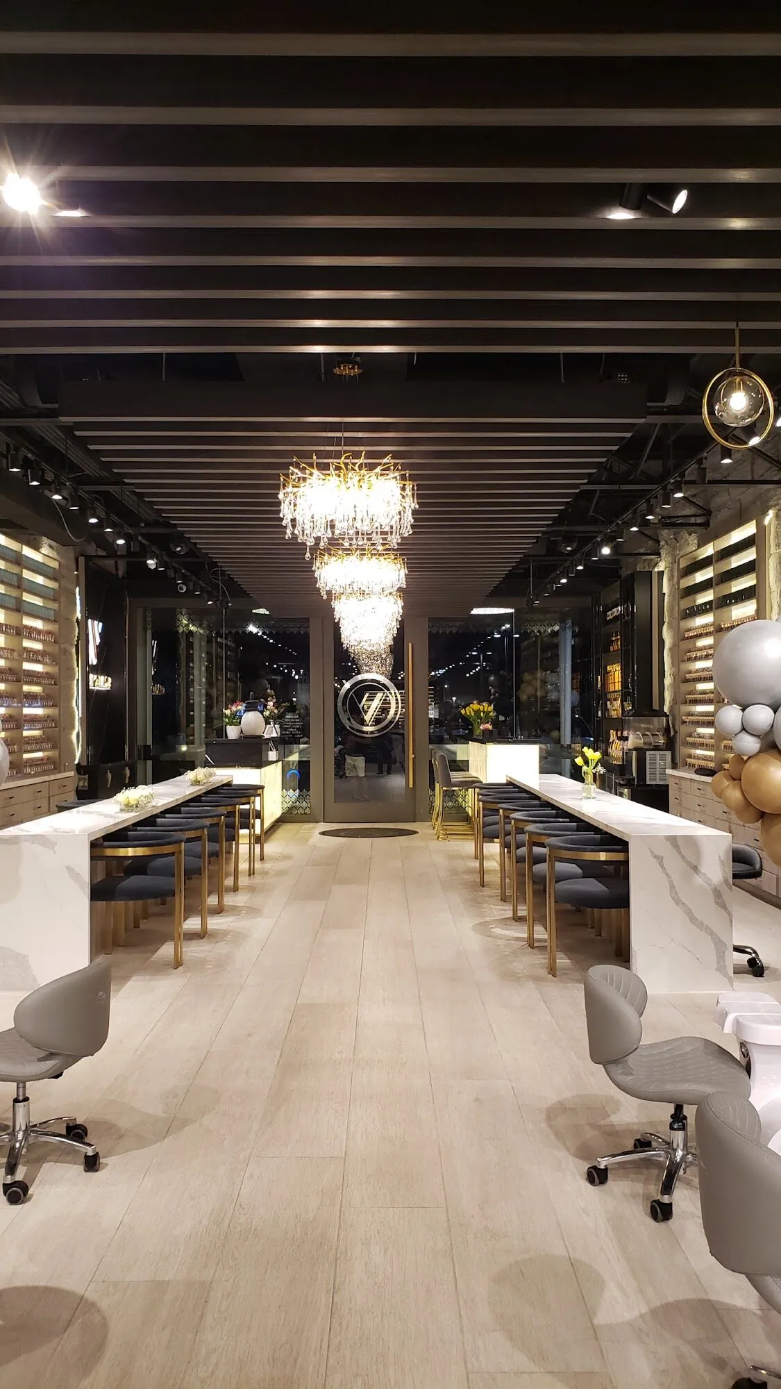 A crystal chandelier over the central walkway between manicure stations at Aria Nail Bar.