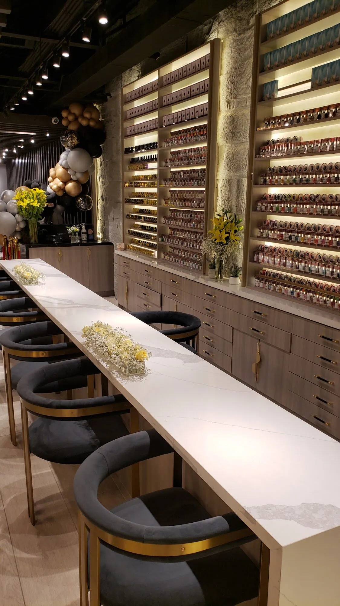 The manicure bar at Aria Nail Bar Phoenix Central running beneath a full wall of backlit nail polish.